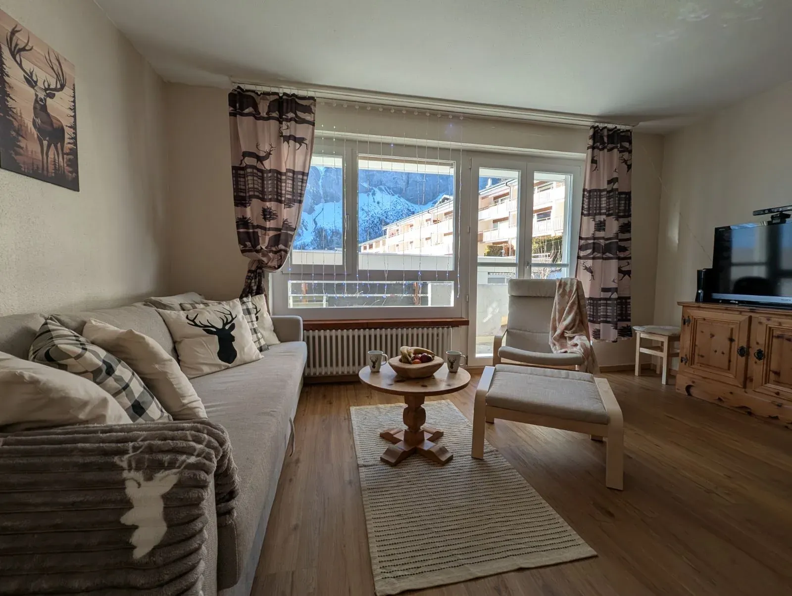 Wohnzimmer der Alpine Siesta mit Sofa, Balkontür und Blick auf die Berge